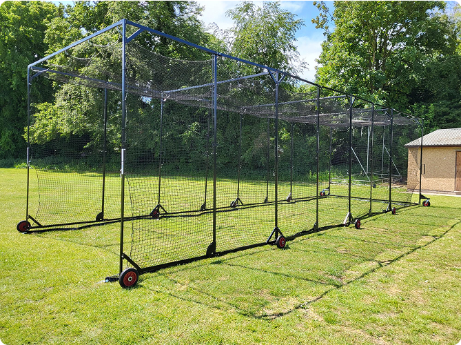 Cricket batting cage with steel frame and red wheels installed on a grassy field, designed by Batting Cages Australia.