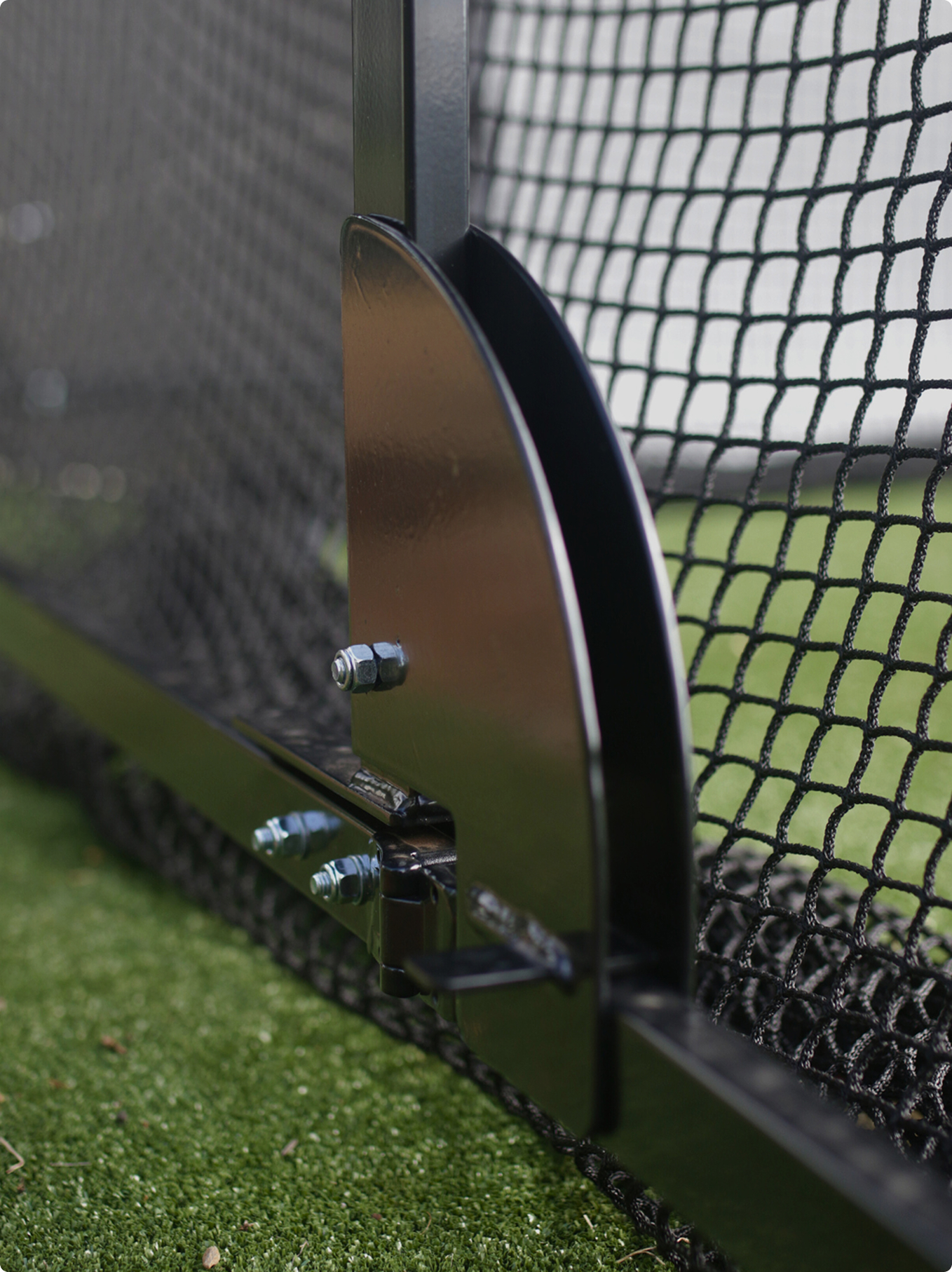 Close-up of ground bracket and bolts securing cricket batting cage netting, part of Batting Cages Australia engineering.